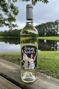 Crazy Sisters sweet white blend wine from Gregory Farms Vineyard photographed outdoors by the pond in Currie North Carolina.